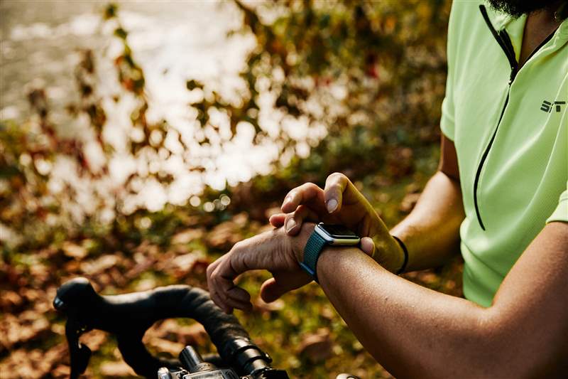 騎自行車的人正在檢查他們的 Apple Watch